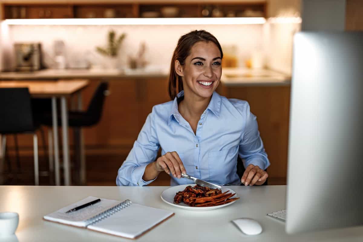 Jeune femme qui déjeune à son bureau